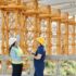 a man and a woman with ppe s talking at a construction site