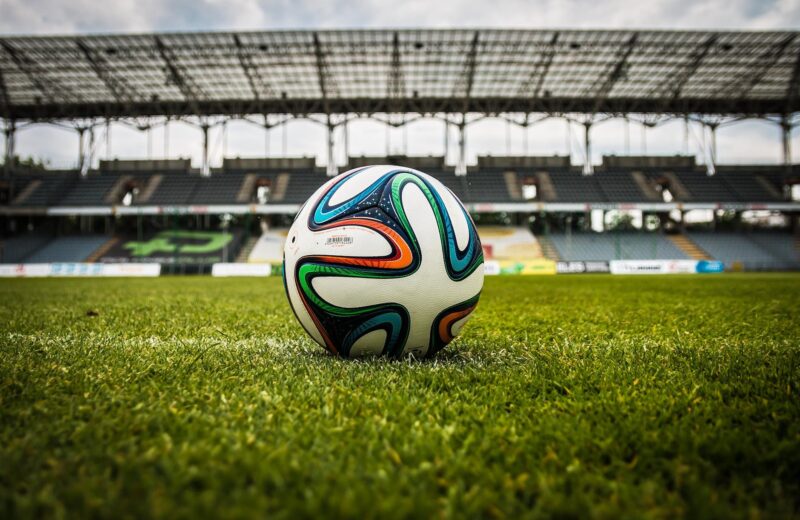 multicolored soccer ball on green field