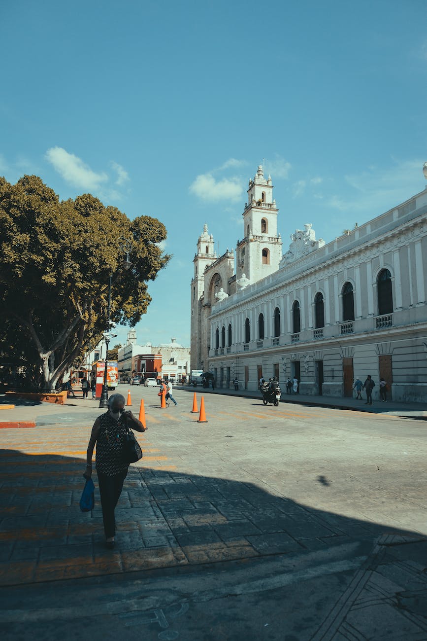 people walking on street sidewalk near museo de arte contemporaneo ateneo in merida mexico